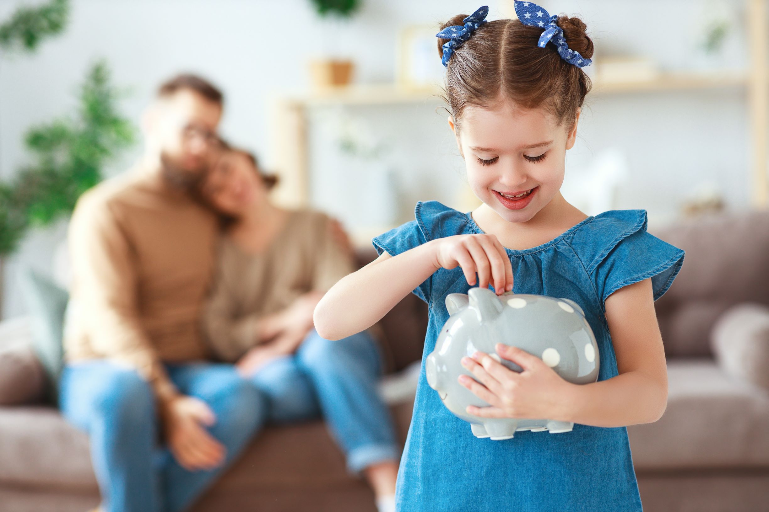 Child saving money while parents look on proudly